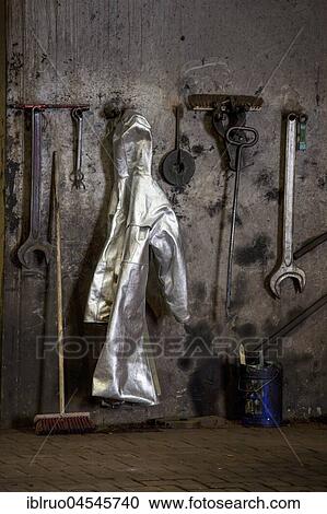 Stock Image - Protective suit of a steel worker hanging on the wall at furnace 8, ThyssenKrupp ironworks, Duisburg, Ruhr area, North Rhine-Westphalia, Germany, Europe. Fotosearch