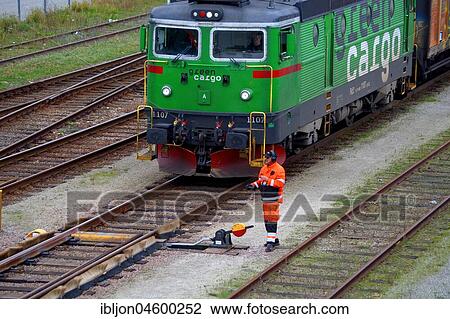 Railway worker waiting for cargo train's take off on railway station, Ystad, Scania, Sweden, Europe View Large Photo Image Stock Image - Railway worker waiting for cargo train's take off on railway station, Ystad, Scania, Sweden, Europe. Fotosearch