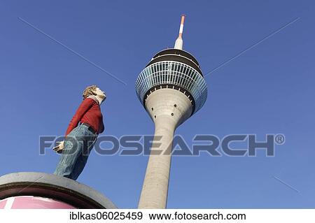 Realistic female figure on an advertising pillar in front of the Rhine Tower, column saint Marlis, sculpture by Christoph Pöggeler, Media Harbour Düsseldorf, North Rhine-Westphalia, Germany, Europe View Large Photo Image Stock Photo - Realistic female figure on an advertising pillar in front of the Rhine Tower, column saint Marlis, sculpture by Christoph Pöggeler, Media Harbour Düsseldorf, North Rhine-Westphalia, Germany, Europe. Fotosearch