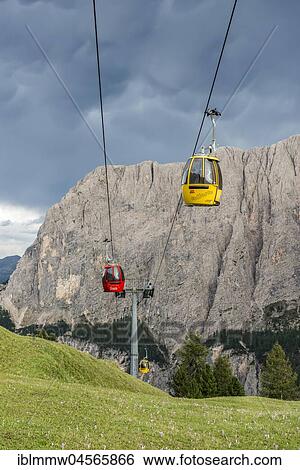 Stock Photograph - Red and yellow gondola, cable car on the Gardena Pass, Passo Gardena, in the back Sella Group, nature park Park Puez-Geisler, Dolomites, Selva di Val Gardena, South Tyrol, Trentino-Alto Adige, Italy, Europe. Fotosearch