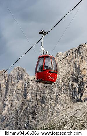 Stock Photography - Red gondola, cable car on the Gardena Pass, Passo Gardena, Sella Group in the back, Puez-Geisler nature park Park, Dolomites, Selva di Val Gardena, South Tyrol, Trentino-Alto Adige, Italy, Europe. Fotosearch