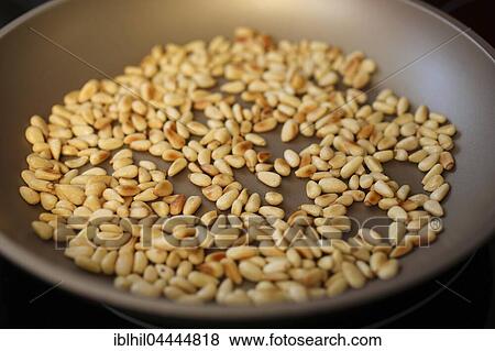 Stock Photo - Roasted pine nuts in the pan. Fotosearch