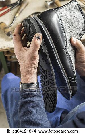 Picture - Shoemaker, hands attaching sole with glue and half-finished shoe with sewn in midsole, Kainisch, Styria, Austria, Europe. Fotosearch