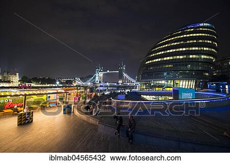 Stock Image - Shore promenade at night, London City Hall, More London Riverside, at the back Tower Bridge, London, England, Great Britain. Fotosearch