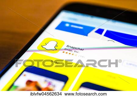 Picture - Snapchat app in the Apple App Store, instant messenger service, social network, app icon, display on a screen from mobile phone, iPhone, iOS, smartphone, macro recording, detail, full-frame format.. Fotosearch