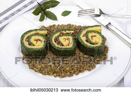 Stock Image - South German cuisine, polenta spinach roulade on alpine lentils arranged on plate, bay leaves, Germany, Europe. Fotosearch
