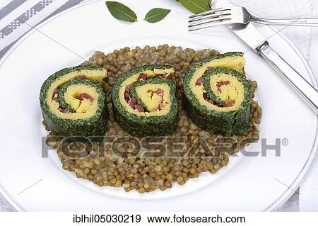 Stock Photo - South German cuisine, polenta spinach roulade on alpine lentils arranged on plate, bay leaves, Germany, Europe. Fotosearch