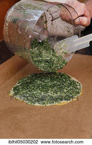 Stock Image - South German cuisine, preparation spinach, spinach puree on baking paper pouring for polenta spinach roulade, bowl, Germany, Europe. Fotosearch
