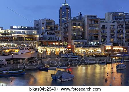 Stock Photo - Spinola Bay with terrace taverns and Portomaso Tower, evening atmosphere, St. Julian's, Malta, Europe. Fotosearch