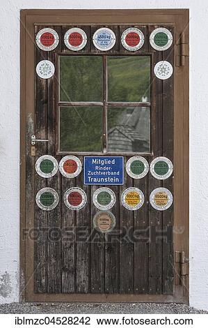 Stock Image - Stable door with milk yield plaques, Upper Bavaria Germany. Fotosearch
