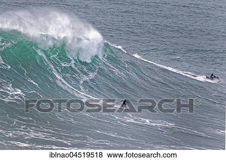 Stock Photo - Surfers in a wave, Nazare, Portugal, Europe. Fotosearch