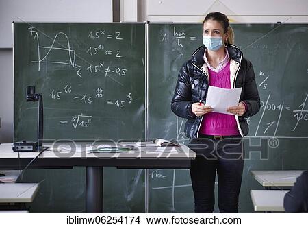 Picture - Teacher with winter jacket and face mask in classroom teaching, gestures, corona crisis, Stuttgart, Baden-Württemberg, Germany, Europe. Fotosearch