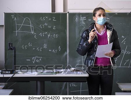 Stock Image - Teacher with winter jacket and face mask in classroom teaching, gestures, corona crisis, Stuttgart, Baden-Württemberg, Germany, Europe. Fotosearch