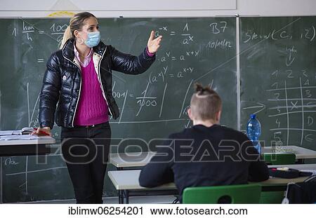 Teacher with winter jacket and face mask in classroom teaching, gestures, corona crisis, Stuttgart, Baden-Württemberg, Germany, Europe View Large Photo Image Stock Image - Teacher with winter jacket and face mask in classroom teaching, gestures, corona crisis, Stuttgart, Baden-Württemberg, Germany, Europe. Fotosearch