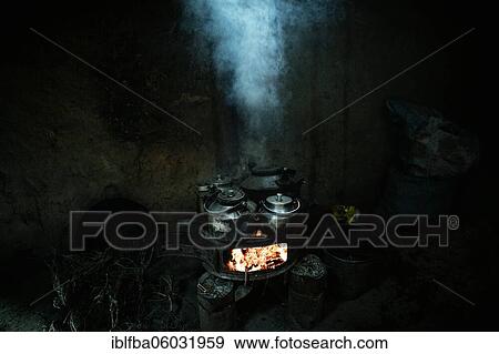 Stock Photo - Teapots with milk tea on an oven with blazing embers, Khandud, Wakhan Corridor, Afghanistan, Asia. Fotosearch