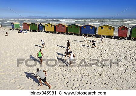 Stock Photo - Teenagers play rugby in front of colourful beach houses, Muizenberg, False Bay, Western Cape, South Africa, Africa. Fotosearch