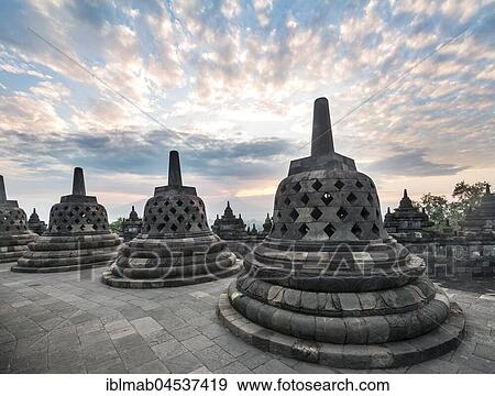Stock Photo - Temple complex Borobudur at sunrise, Stupas, cloudy sky, Borobudur, Yogyakarta, Java, Indonesia, Asia. Fotosearch