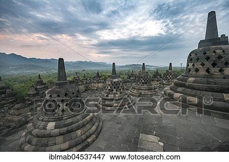 Stock Photo - Temple complex Borobudur at sunrise, Stupas, cloudy sky, Borobudur, Yogyakarta, Java, Indonesia, Asia. Fotosearch