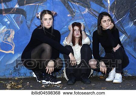 Stock Photo - Three girls, teenagers, rebels, bad mood, negative, negative mood, boycott, relationship, friends, piercing, quarrel, graffiti, quarrel. Fotosearch