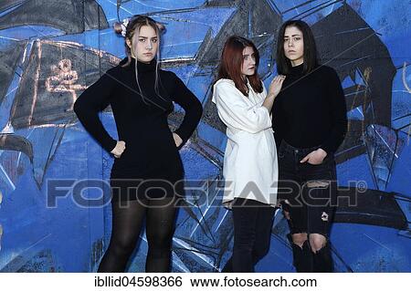 Stock Photograph - Three girls, teenagers, rebels, bad mood, negative, negative mood, boycott, relationship, friends, piercing, quarrel, graffiti, quarrel. Fotosearch