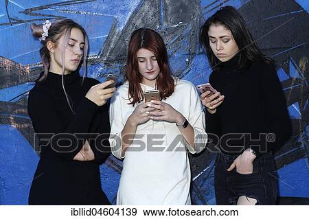 Three girls, teenagers, with mobile phones, puberty View Large Photo Image Stock Photo - Three girls, teenagers, with mobile phones, puberty. Fotosearch