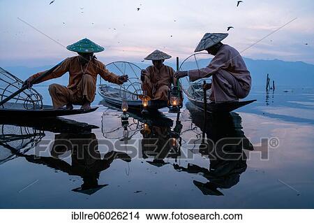 Three traditional fishermen sitting with lamps on their small boats, at sunrise, Lake Inle, Myanmar, Asia View Large Photo Image Picture - Three traditional fishermen sitting with lamps on their small boats, at sunrise, Lake Inle, Myanmar, Asia. Fotosearch