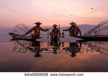 Three traditional fishermen sitting with lamps on their small boats, at sunrise, Lake Inle, Myanmar, Asia View Large Photo Image Stock Photo - Three traditional fishermen sitting with lamps on their small boats, at sunrise, Lake Inle, Myanmar, Asia. Fotosearch