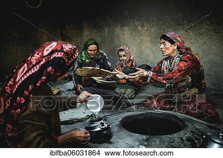 Three woman and a child baking flat bread, smoking kitchen in a mud house with stone oven, sedentary Wakhi, Khandud, Wakhan corridor, Afghanistan, Asia View Large Photo Image Picture - Three woman and a child baking flat bread, smoking kitchen in a mud house with stone oven, sedentary Wakhi, Khandud, Wakhan corridor, Afghanistan, Asia. Fotosearch