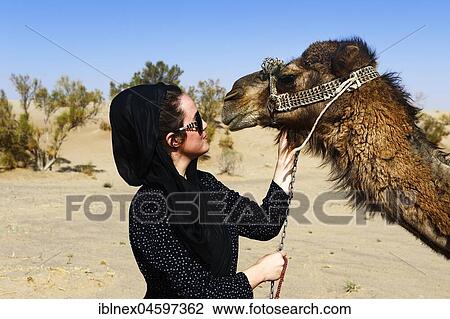 Stock Image - Tourist with camel on camel tour, desert Wadi Rum, near Matinabad, Iran, Asia. Fotosearch