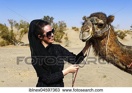 Stock Image - Tourist with camel on camel tour, desert Wadi Rum, near Matinabad, Iran, Asia. Fotosearch