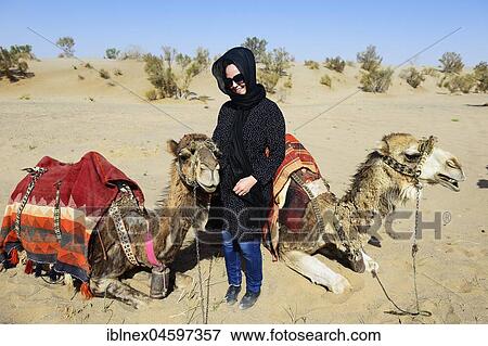 Stock Photo - Tourist with resting camels on camel tour, desert Wadi Rum, near Matinabad, Iran, Asia. Fotosearch