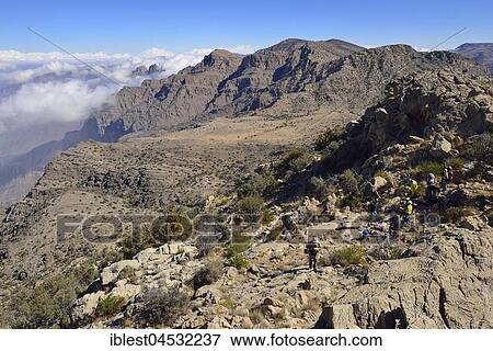 Stock Photo - Tourists hiking in the Al Hajar al Gharbi mountains, Dakhiliyah, Oman, Asia. Fotosearch
