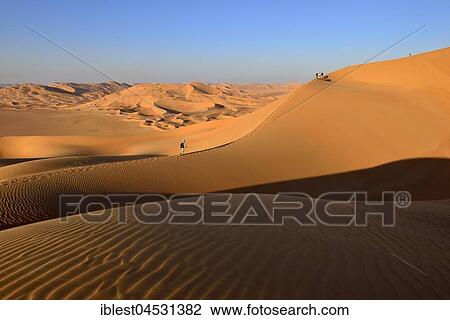 Stock Image - Tourists hiking in the sanddunes, Rub al Khali desert, empty quarter, Dhofar, Oman, Asia. Fotosearch