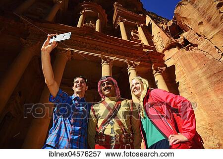 Tourists take a shot with a Bedouin Policeman at Khazne al Firaun, Al Khazneh treasury building, Petra, Wadi Musa, Jordan, Asia View Large Photo Image Stock Photo - Tourists take a shot with a Bedouin Policeman at Khazne al Firaun, Al Khazneh treasury building, Petra, Wadi Musa, Jordan, Asia. Fotosearch