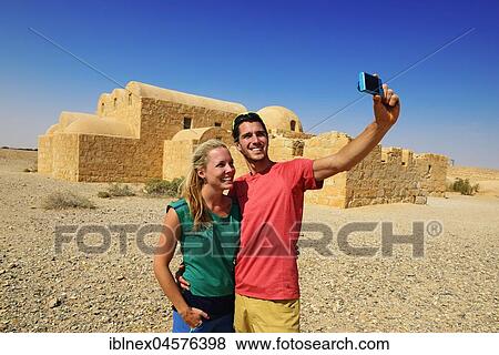 Stock Photo - Tourists taking selfie, Omayyad desert castle, Qasr Amra, Jordan, Asia. Fotosearch