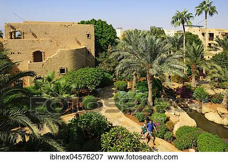 Stock Photo - Tourists walk in Compound of Mövenpick Dead Sea Resort, Jordan, Asia. Fotosearch