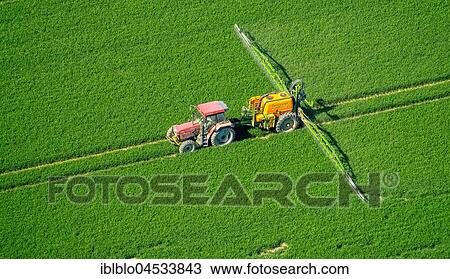 Stock Image - Tracker spraying pesticides on a green grain field, agriculture, aerial photo, Warstein, Sauerland, North Rhine-Westphalia, Germany, Europe. Fotosearch