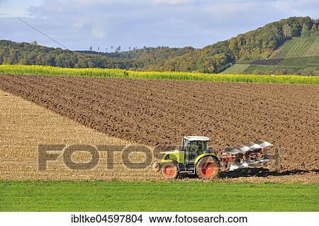Tractor with plough while ploughing on the harvested field, Baden-Württemberg, Germany, Europe View Large Photo Image Picture - Tractor with plough while ploughing on the harvested field, Baden-Württemberg, Germany, Europe. Fotosearch