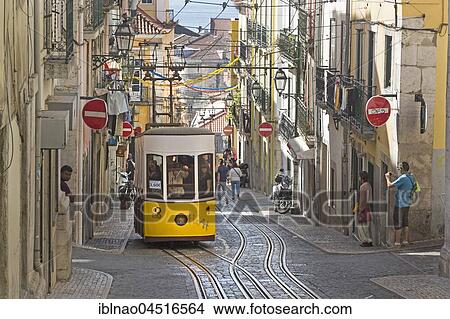 Picture - Tram, gondola passing through narrow street, Lisbon, Portugal, Europe. Fotosearch