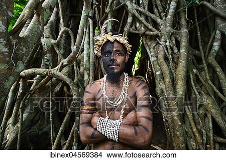 Tribal warrior in front of the roots of the banyan tree (Ficus benghalensis), Ekasup Cultural Village, Efate Island, Vanuatu, South Sea, Oceania View Large Photo Image Picture - Tribal warrior in front of the roots of the banyan tree (Ficus benghalensis), Ekasup Cultural Village, Efate Island, Vanuatu, South Sea, Oceania. Fotosearch