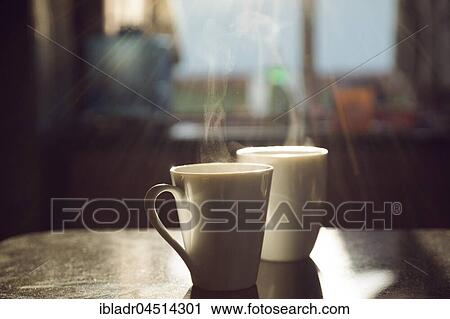Two cups of coffee, steaming, standing on table, backlit View Large Photo Image Stock Image - Two cups of coffee, steaming, standing on table, backlit. Fotosearch