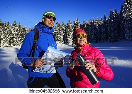 Stock Photograph - Two hikers on a premium winter hiking trail, take a break, Hemmersuppenalm, Reit im Winkl, Chiemgau, Oberbayern, Bavaria, Germany, Europe. Fotosearch
