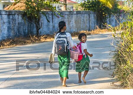 Two indigenous girls on the way to school, street scene, Chaung Tha Beach, Myanmar, Asia View Large Photo Image Picture - Two indigenous girls on the way to school, street scene, Chaung Tha Beach, Myanmar, Asia. Fotosearch