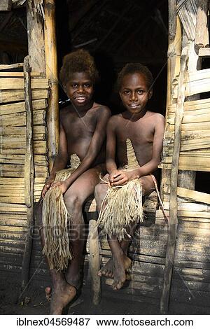 Two local children sitting in front of a hut, Yakeel Custom Village, Tanna Island, Vanuatu, South Sea, Oceania View Large Photo Image Stock Photo - Two local children sitting in front of a hut, Yakeel Custom Village, Tanna Island, Vanuatu, South Sea, Oceania. Fotosearch