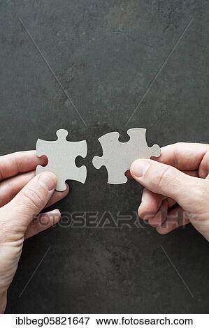 Two puzzle pieces in your hands View Large Photo Image Stock Photo - Two puzzle pieces in your hands. Fotosearch