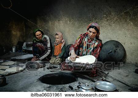 Two woman and a child baking flat bread, smoking kitchen, traditional mud house with stone oven, one of the woman flattening a loaf of bread, Wakhan corridor, Khandud, Afghanistan, Asia View Large Photo Image Stock Image - Two woman and a child baking flat bread, smoking kitchen, traditional mud house with stone oven, one of the woman flattening a loaf of bread, Wakhan corridor, Khandud, Afghanistan, Asia. Fotosearch
