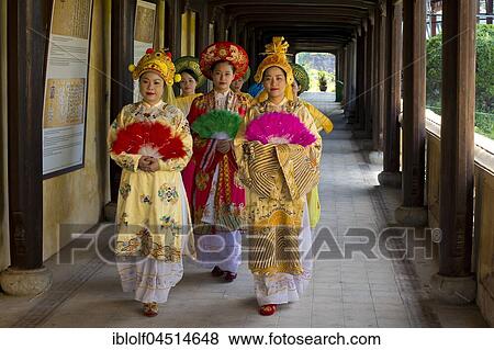 Stock Photo - Vietnamese extras in traditional robes walking through imperial palace Hoang Thanh, Forbidden City, Hue, Vietnam, Asia. Fotosearch