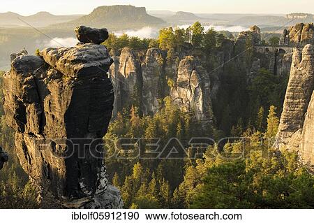 Stock Image - View of the Bastei with Wehlnadel and Wehlgrund to the Lilienstein at sunrise, Saxony, Germany, Elbe Sandstone Mountains, Saxon Switzerland National Park, Europe. Fotosearch
