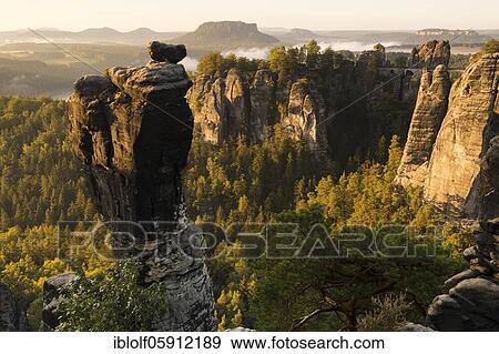 Stock Photo - View of the Bastei with Wehlnadel and Wehlgrund to the Lilienstein at sunrise, Saxony, Germany, Elbe Sandstone Mountains, Saxon Switzerland National Park, Europe. Fotosearch