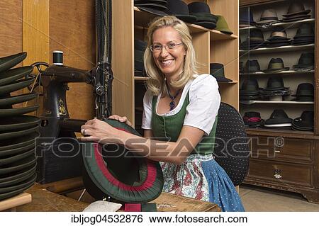 Woman sewing silk ribbon and inner lining on hat edge, finished hats on shelves behind, hatmaker workshop, Bad Aussee, Styria, Austria, Europe View Large Photo Image Stock Photograph - Woman sewing silk ribbon and inner lining on hat edge, finished hats on shelves behind, hatmaker workshop, Bad Aussee, Styria, Austria, Europe. Fotosearch